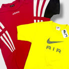 Red Adidas shirt and yellow Nike shirt on a white background